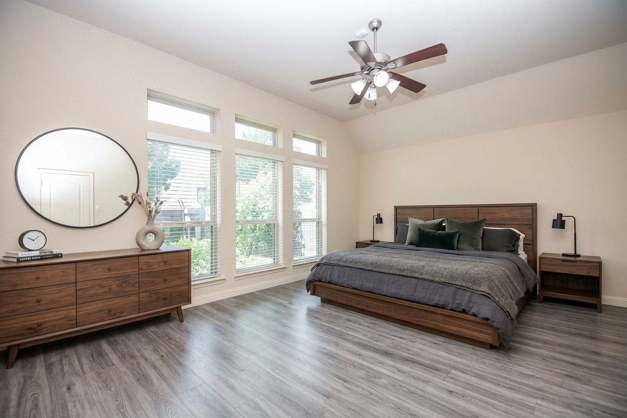 Spacious master bedroom with abundant natural light, featuring a sleek wooden bed frame, matching dresser, and modern ceiling fan.  AI designed