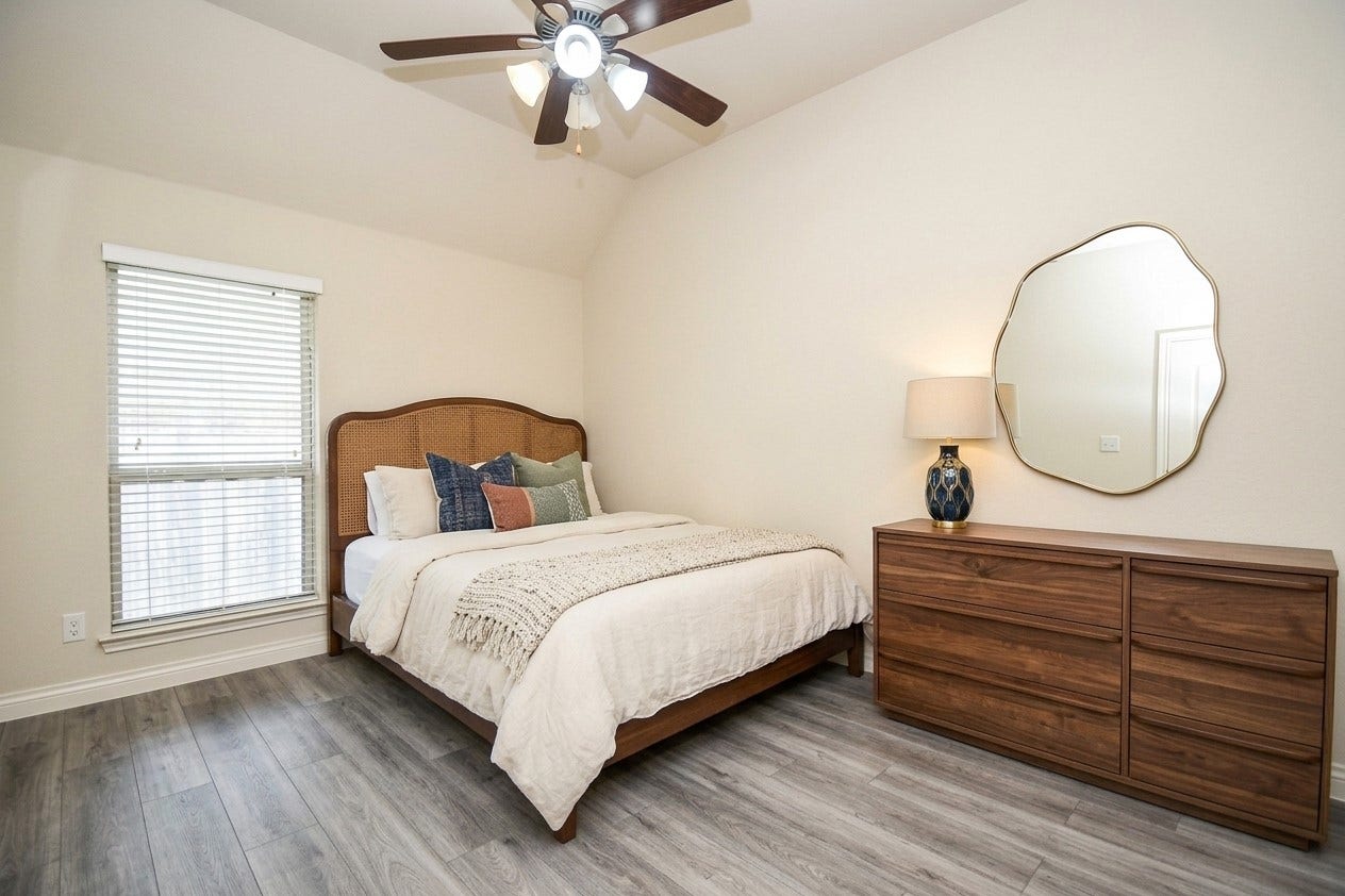 Cozy bedroom featuring a comfortable bed with stylish bedding, a sleek wooden dresser topped with a chic lamp, and a unique mirror. Natural light streams in through the window, enhancing the warm, inviting atmosphere.  AI designed