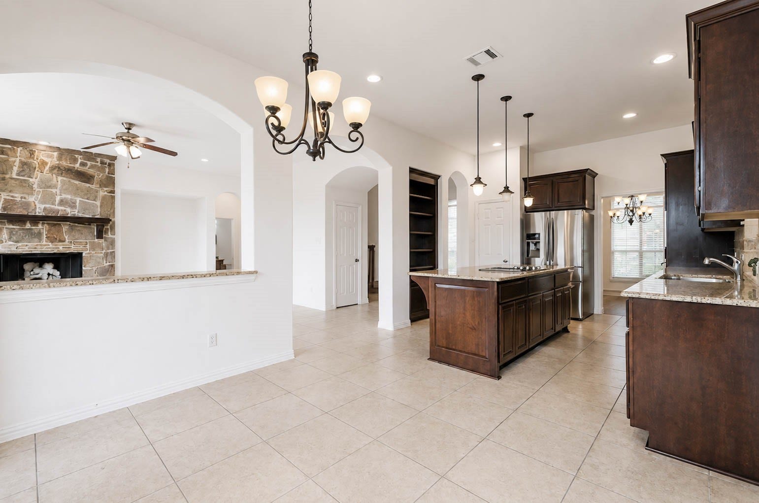 3814 Bluffstone Court, Sugar Land, TX 77479 Open kitchen and breakfast area with granite surfaces, abundant cabinetry, stainless steel appliances and sightlines to the living room.
