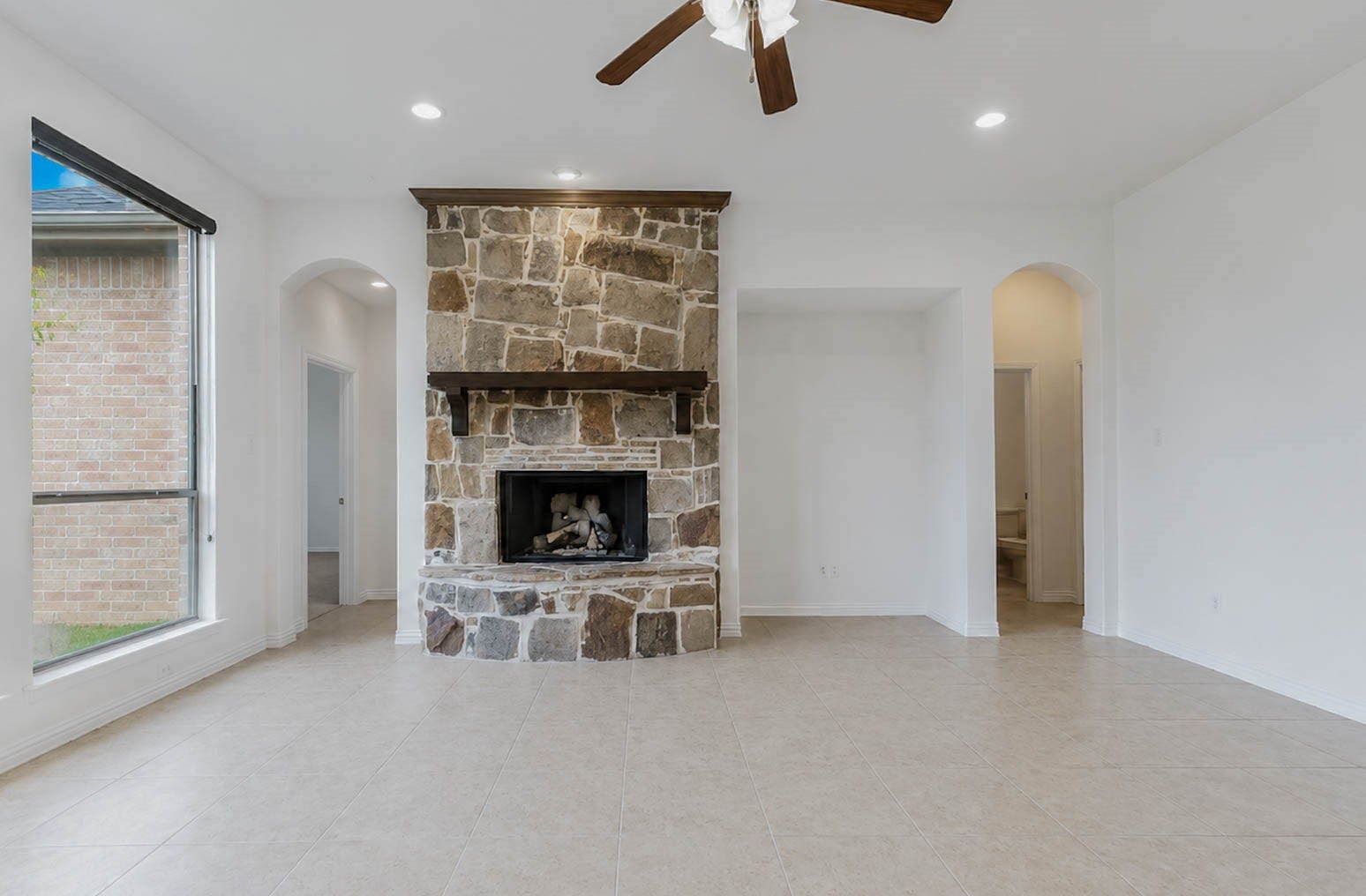 3814 Bluffstone Court, Sugar Land, TX 77479 Spacious family room centers around a floor to ceiling stone fireplace, with high ceilings, natural light and flexible living space.