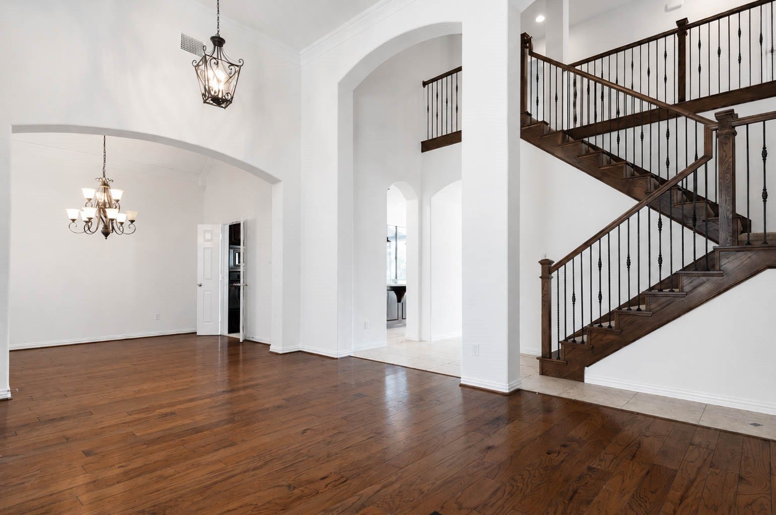3814 Bluffstone Court, Sugar Land, TX 77479 Dramatic two story interior showcases rich wood flooring, graceful arches and a striking staircase with wrought iron detailing.