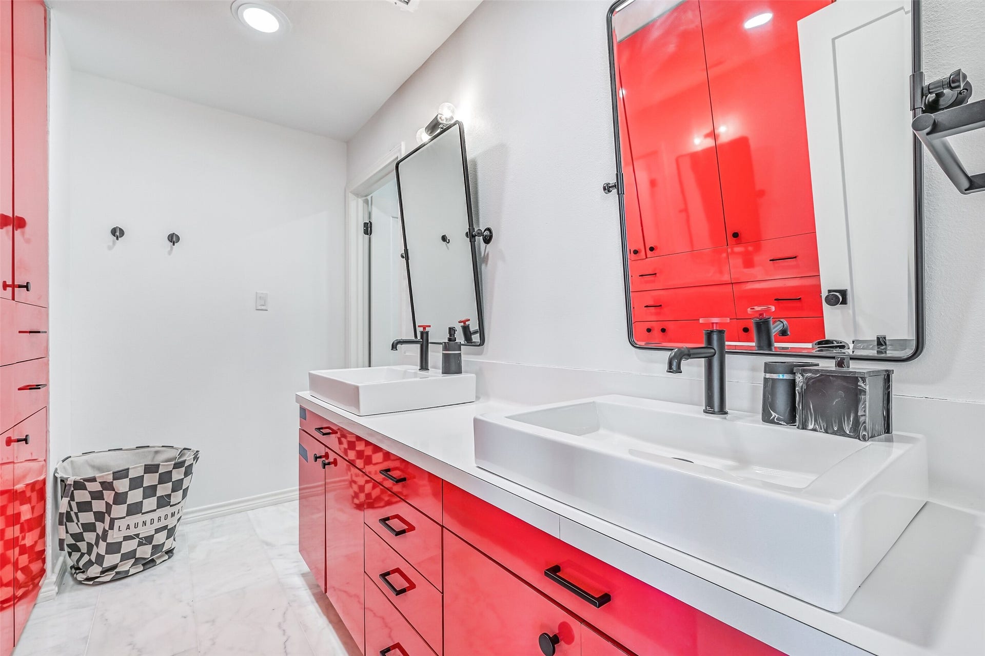 1614 Castaway Street, Tiki Island, TX 77554 The bold red vanity gives this ensuite an unexpected pop of personality. Even the secondary spaces have a sense of fun that fits life on Tiki.