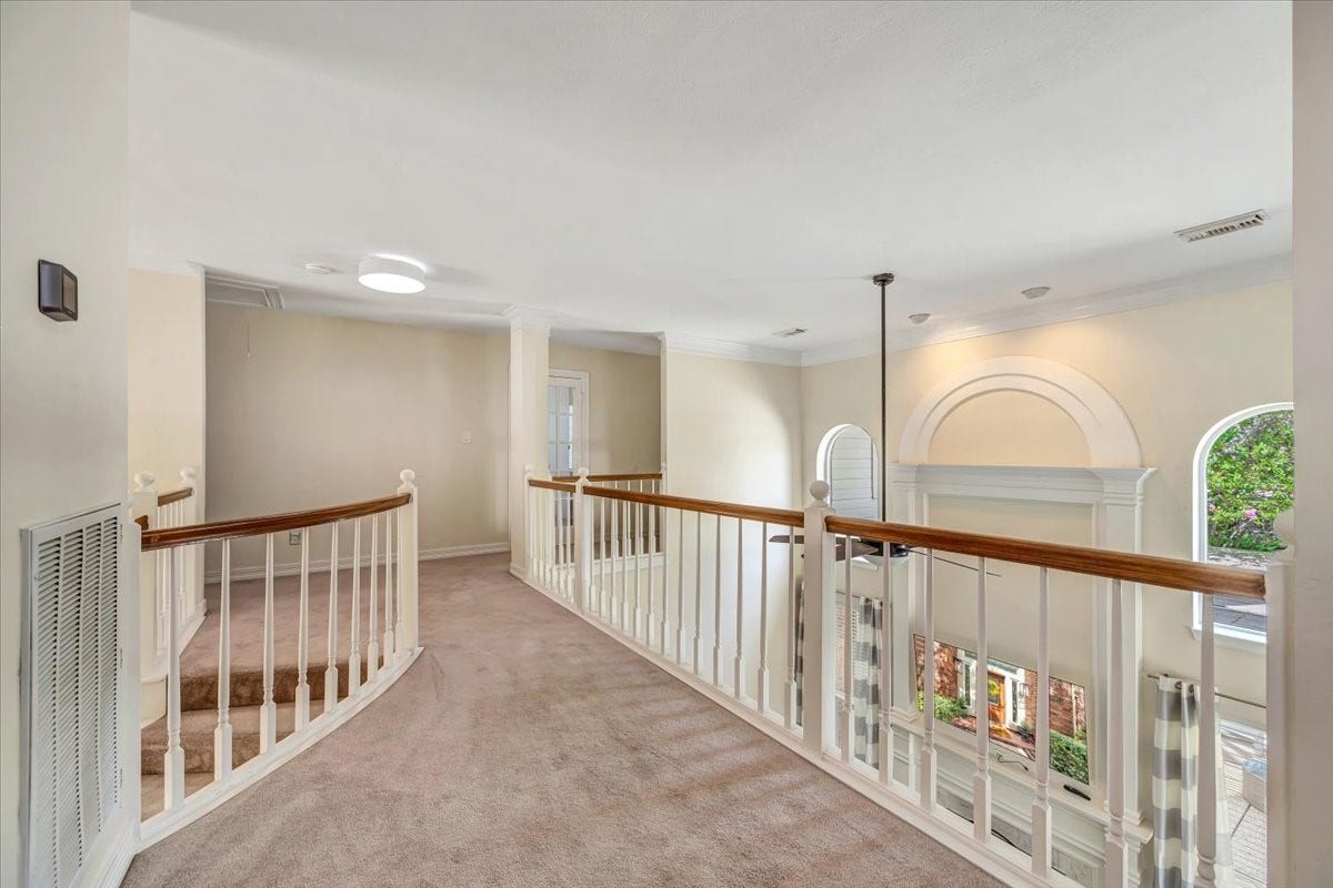Open upstairs landing overlooks the entry below and connects the secondary bedrooms and additional living spaces.