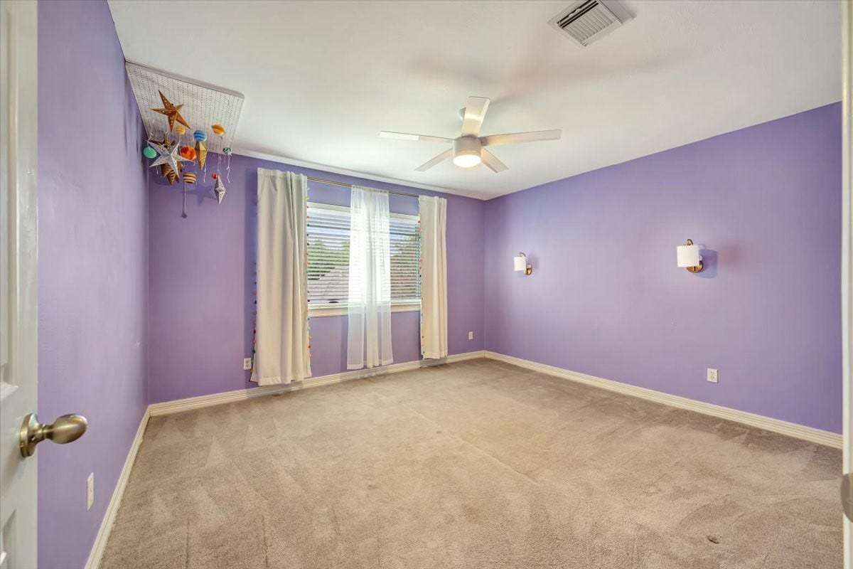 Generously sized secondary bedroom #3 accented by a whimsical celestial mobile and great natural light.