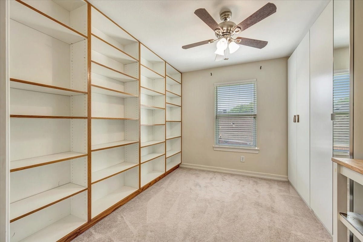 Versatile upstairs bonus room with extensive built-in shelving, cabinetry and workspaceideal for crafting, hobbies, games or organized storage.