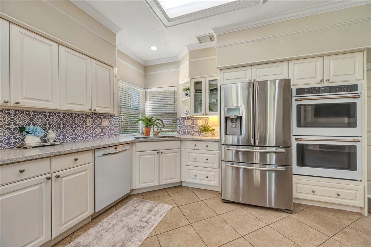 Kitchen includes stainless appliances, double ovens and plenty of surrounding cabinetry for a clean, functional layout.