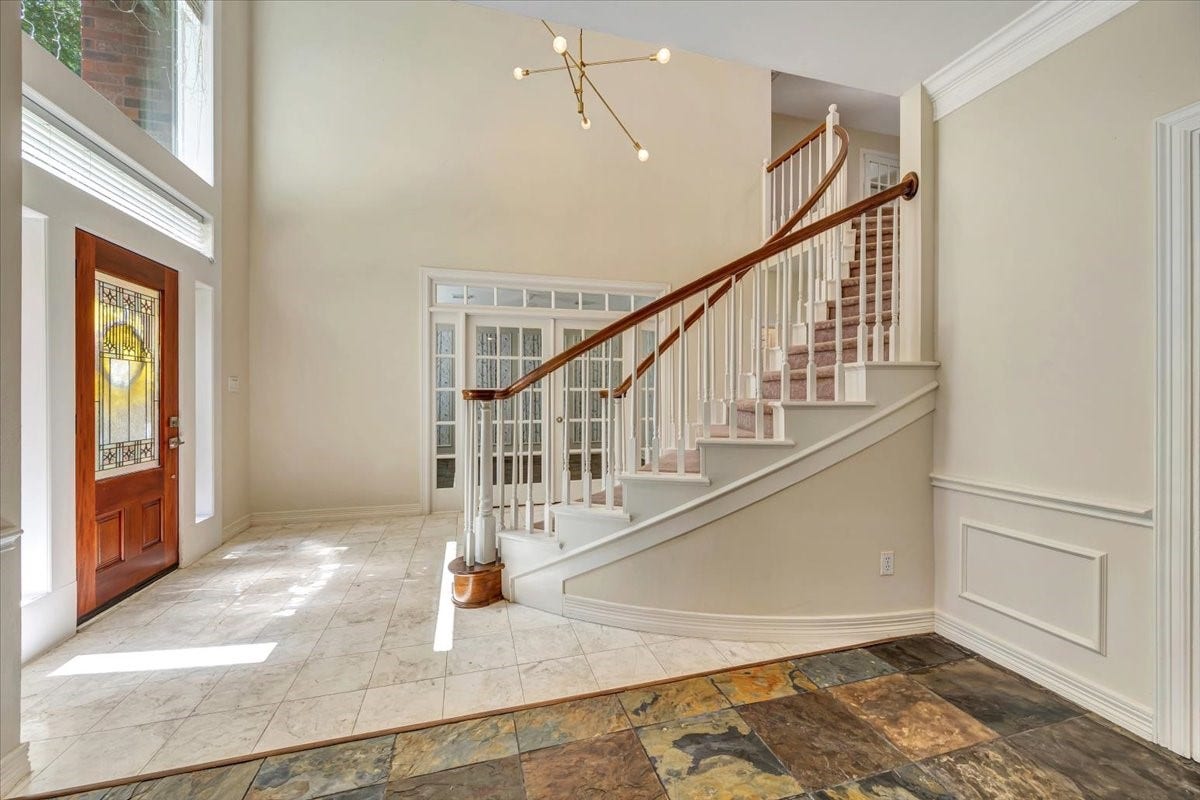 Elegant curved staircase with wood handrail creates an impressive focal point from the moment you enter.