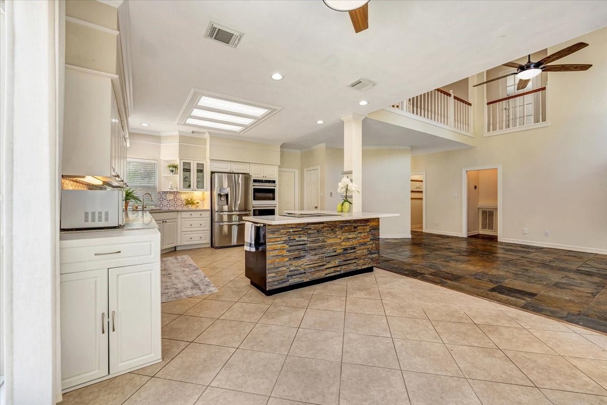 Bright, open kitchen and breakfast area with generous counter space, abundant cabinetry and excellent natural light.