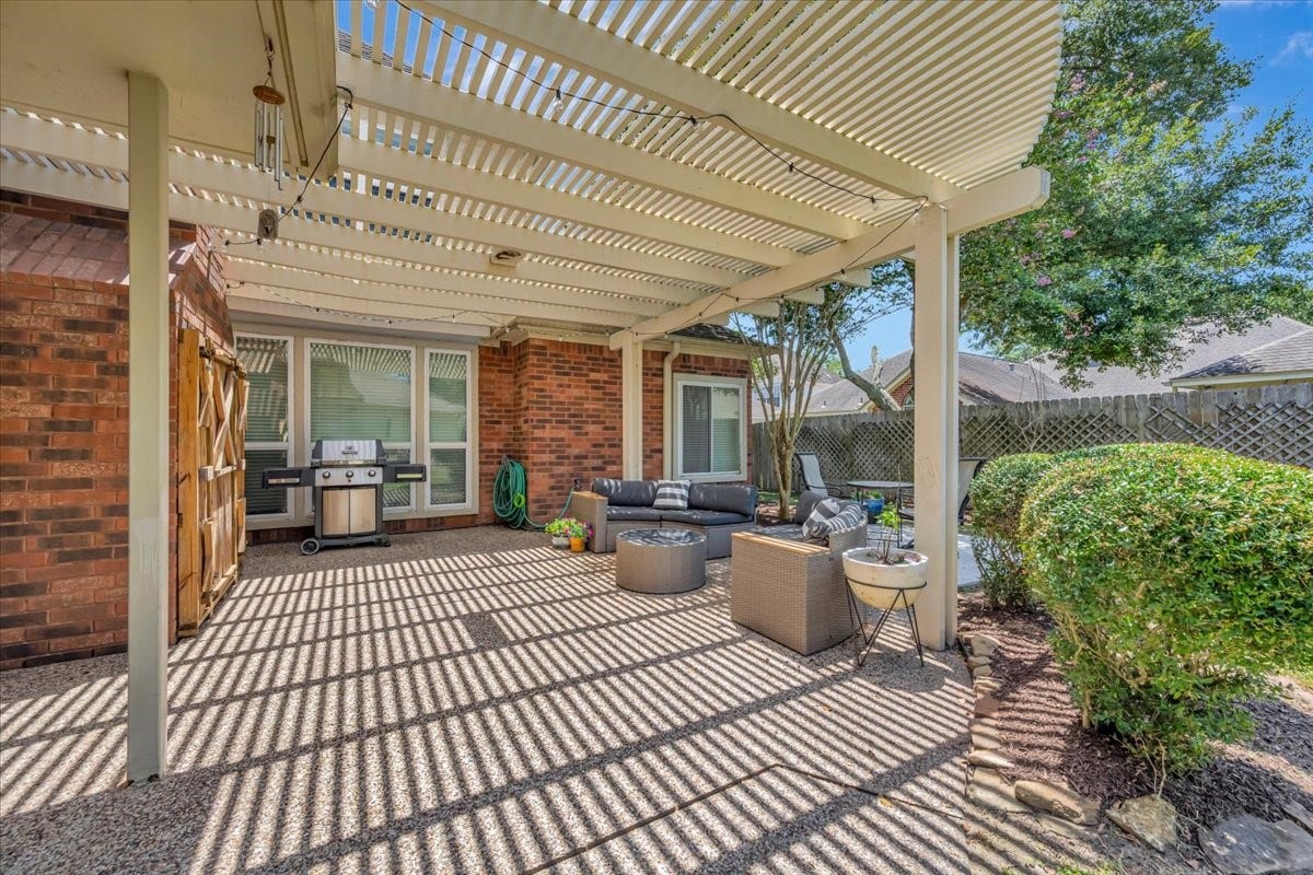 Generous pergola-covered patio offers plenty of room for relaxing, grilling and entertaining outdoors.