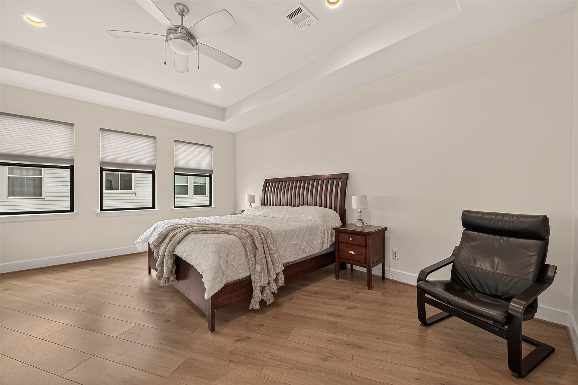 Spacious and sun-filled primary bedroom featuring large windows that provide abundant natural light.