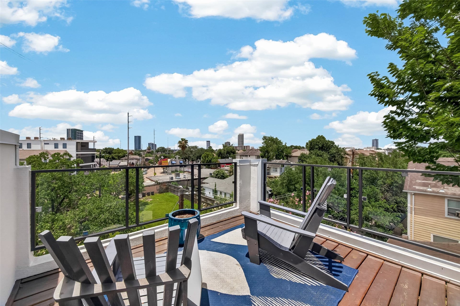 The rooftop deck, offering a scenic view of the city skyline and greenery. Perfect for relaxation and enjoying the outdoors.
