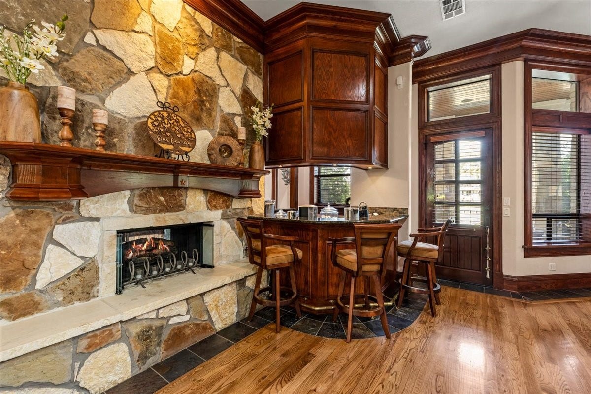 11860 Grand Harbor Boulevard, Montgomery, TX 77356 Otherside of the stone fireplace in the kitchen and breakfast area. Natural gas logs make staring a fire, quick and easy. Snuggle up to the bar and enjoy the fire!