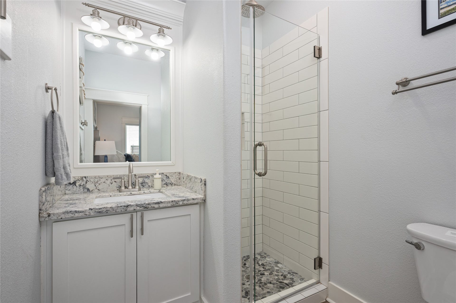 997 S Redfish Street, Crystal Beach, TX 77650 Getting ready feels effortless with a granite-topped vanity and a bright walk-in shower just steps from the bedroom.