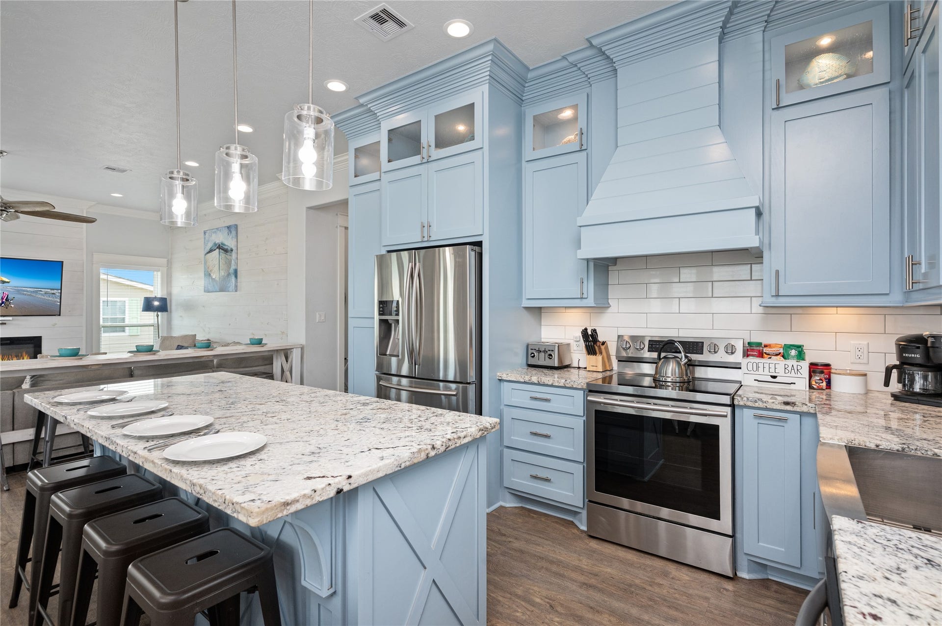 997 S Redfish Street, Crystal Beach, TX 77650 Your coastal-inspired kitchen pairs soft blue cabinetry with granite countertops, stainless appliances, and a statement range hood for a polished finishing touch.