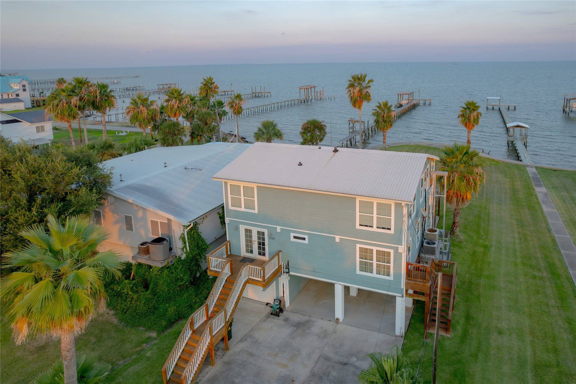 1309 8th Street, San Leon, TX 77539 Sunrises & Serenity on the San Leon Bayfront"! As the sun rises over the bay in San Leon, this beautiful home takes on a warm golden glow, its balconies and wide windows perfectly framing the shimmering water.As dusk settles over the water, the sky transforms into a canvas of soft pinks, oranges, and purples, reflecting gently on the calm bay below.