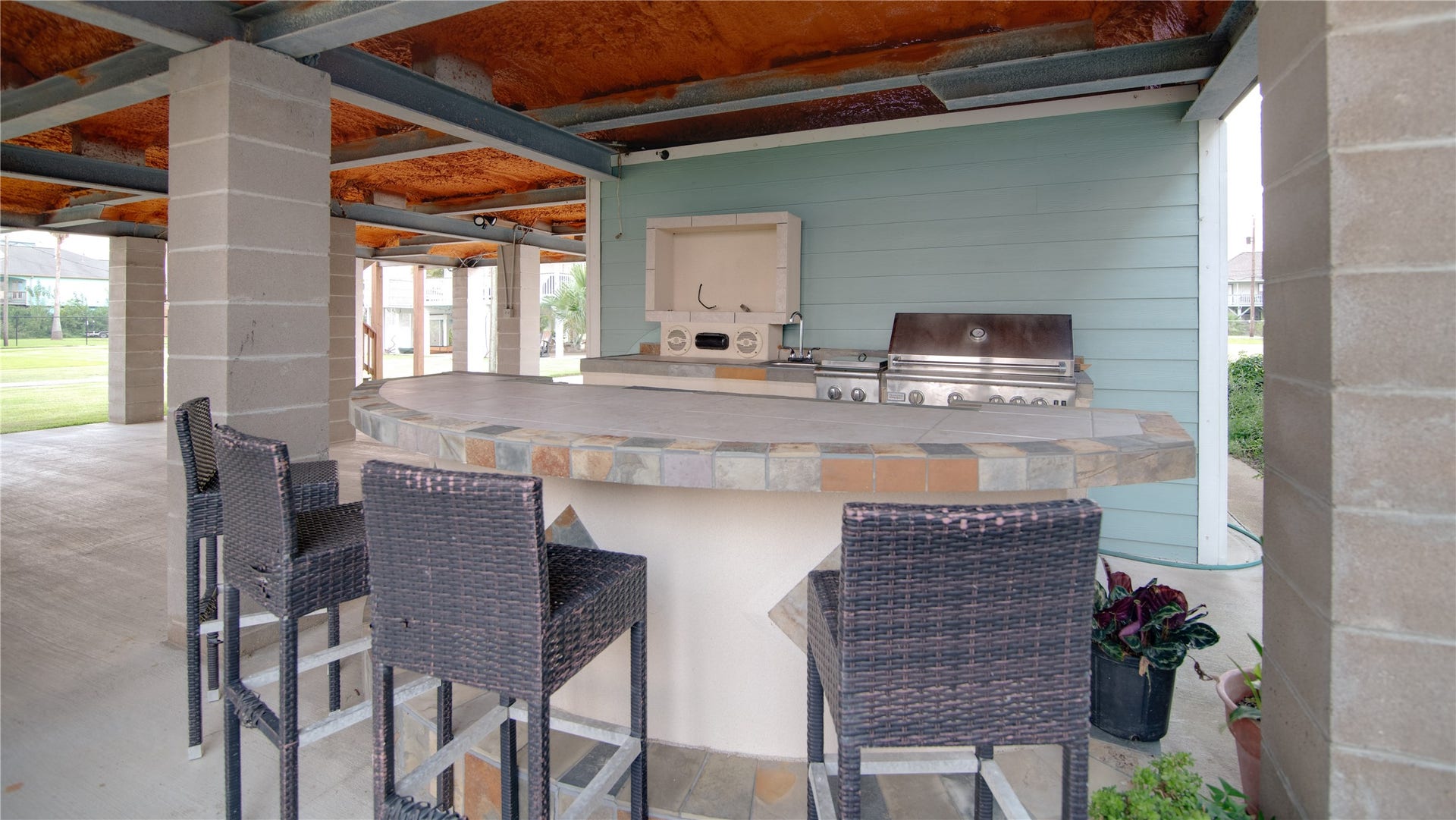 1309 8th Street, San Leon, TX 77539 This outdoor kitchen is a stylish and functional space designed for entertaining and alfresco dining. Equipped with a built-in grill, ample counter space, and storage for utensils and supplies, it makes cooking outdoors effortless. The area is complemented by durable surfaces and thoughtful layout, allowing guests to mingle while meals are prepared, all while enjoying the fresh air and scenic views of the bay.