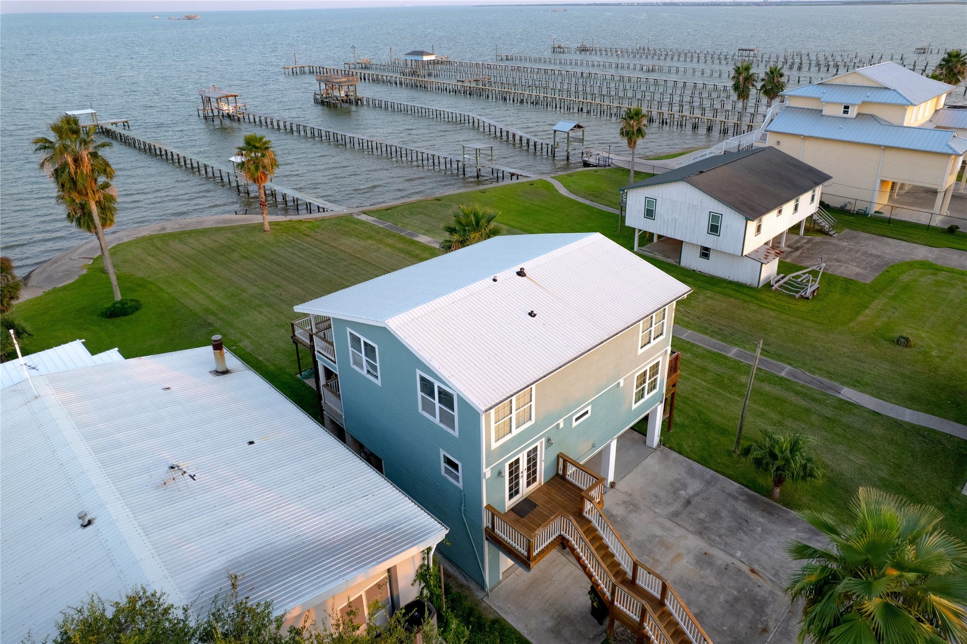 1309 8th Street, San Leon, TX 77539 From above, a drone captures a stunning coastal paradise, where sparkling blue waters meet sandy shorelines dotted with charming homes.