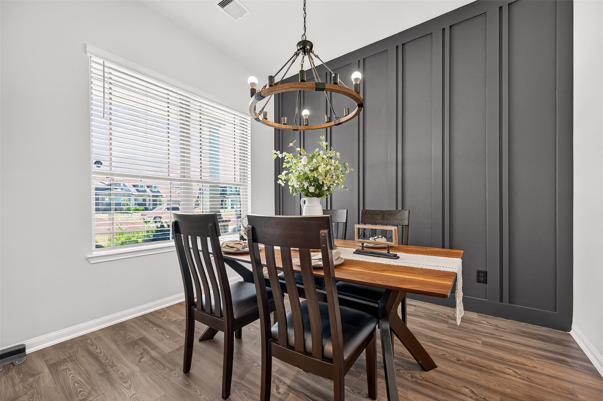 8422 Black Pearl Court, Texas City, TX 77591 Charming dining area with a modern chandelier, featuring a stylish wood accent wall and large window for natural light.