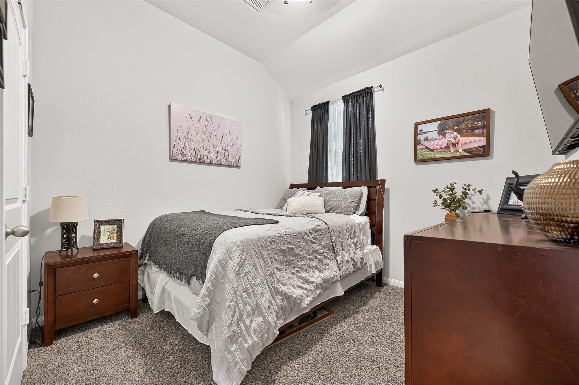 8422 Black Pearl Court, Texas City, TX 77591 Cozy bedroom with plush carpeting, featuring a comfortable bed and stylish dark wood furniture. Natural light filters through the window, complementing the room's soothing color palette.