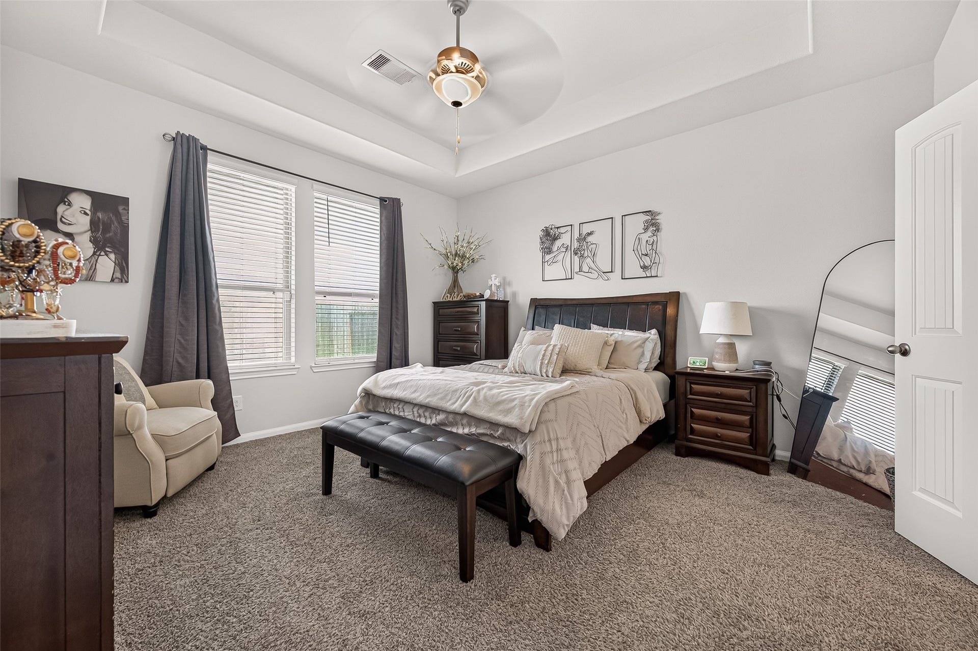 8422 Black Pearl Court, Texas City, TX 77591 Spacious and inviting bedroom with plush carpeting, featuring a cozy bed, elegant furnishings, and abundant natural light from large windows.