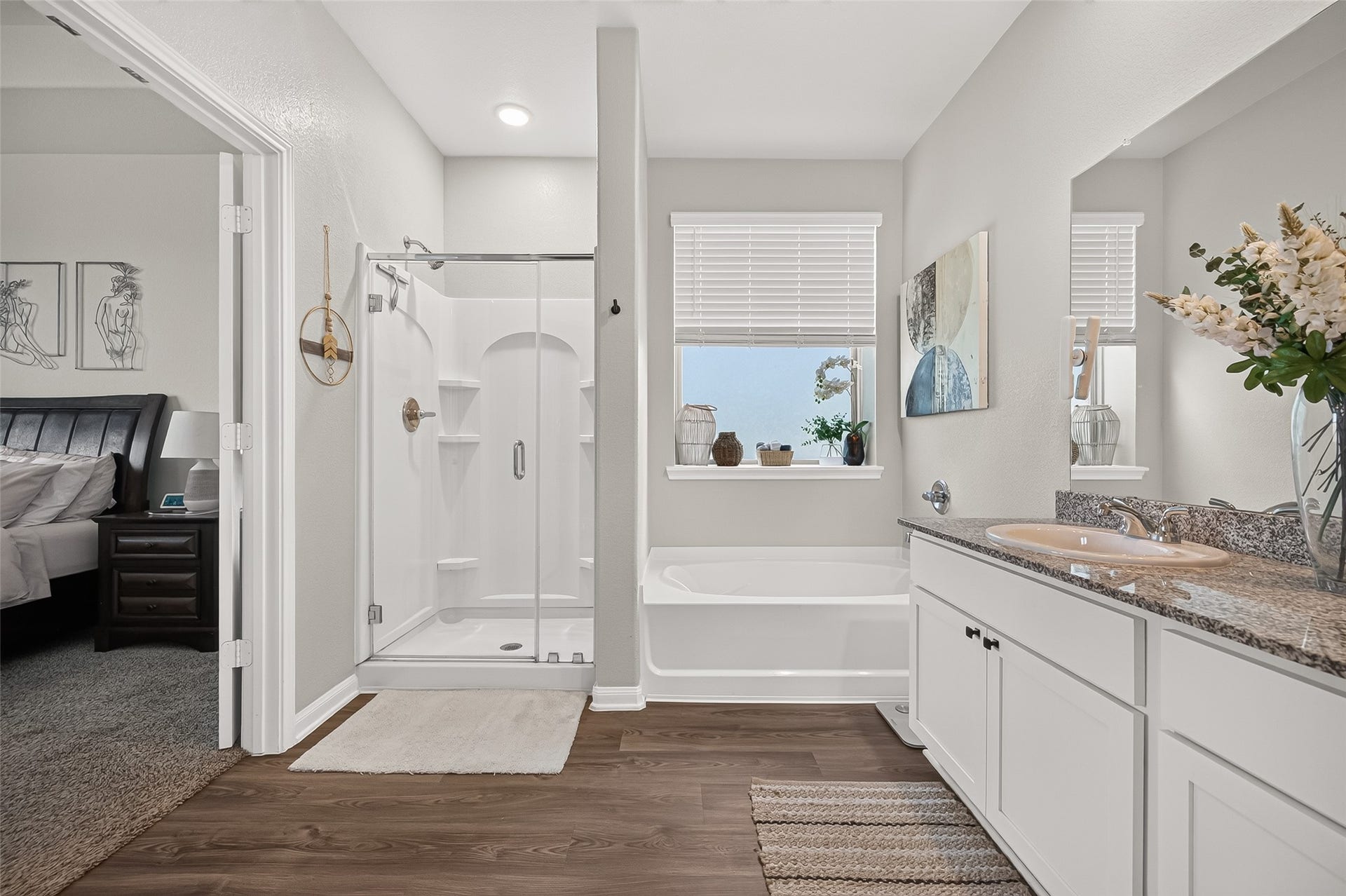 8422 Black Pearl Court, Texas City, TX 77591 Bright and modern bathroom featuring a spacious glass-enclosed shower, cozy bathtub, and elegant granite countertop with dual sinks, seamlessly connecting to the bedroom.