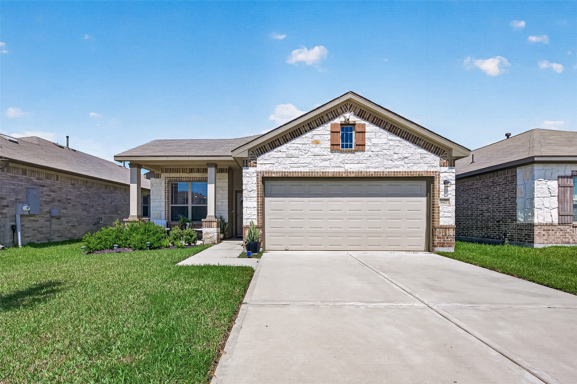 8422 Black Pearl Court, Texas City, TX 77591 Charming single-story home with a modern stone facade, spacious driveway, and well-maintained front yard.
