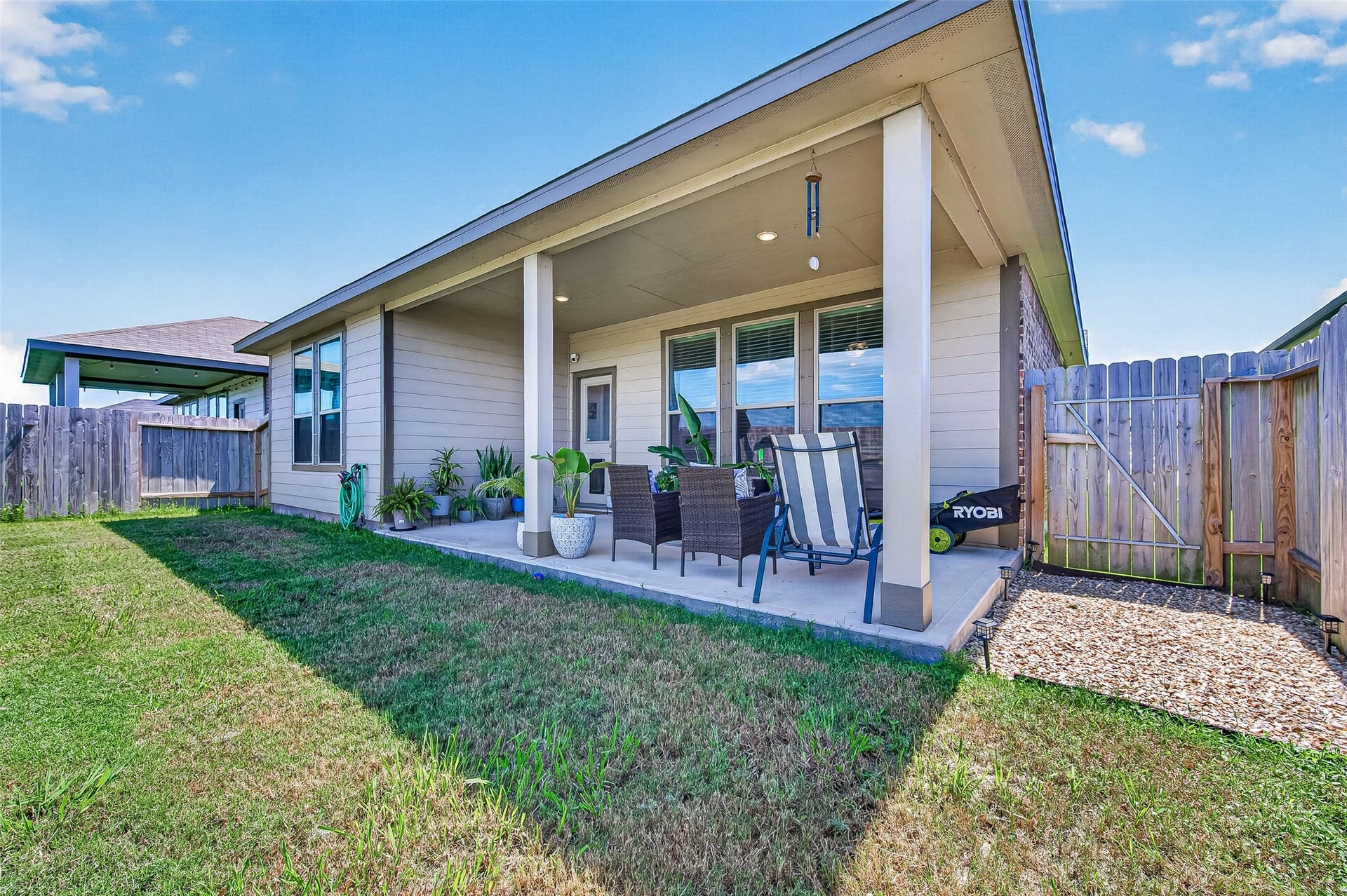 8422 Black Pearl Court, Texas City, TX 77591 Charming covered patio with cozy seating area, perfect for outdoor relaxation, set within a fenced backyard offering privacy and tranquility.