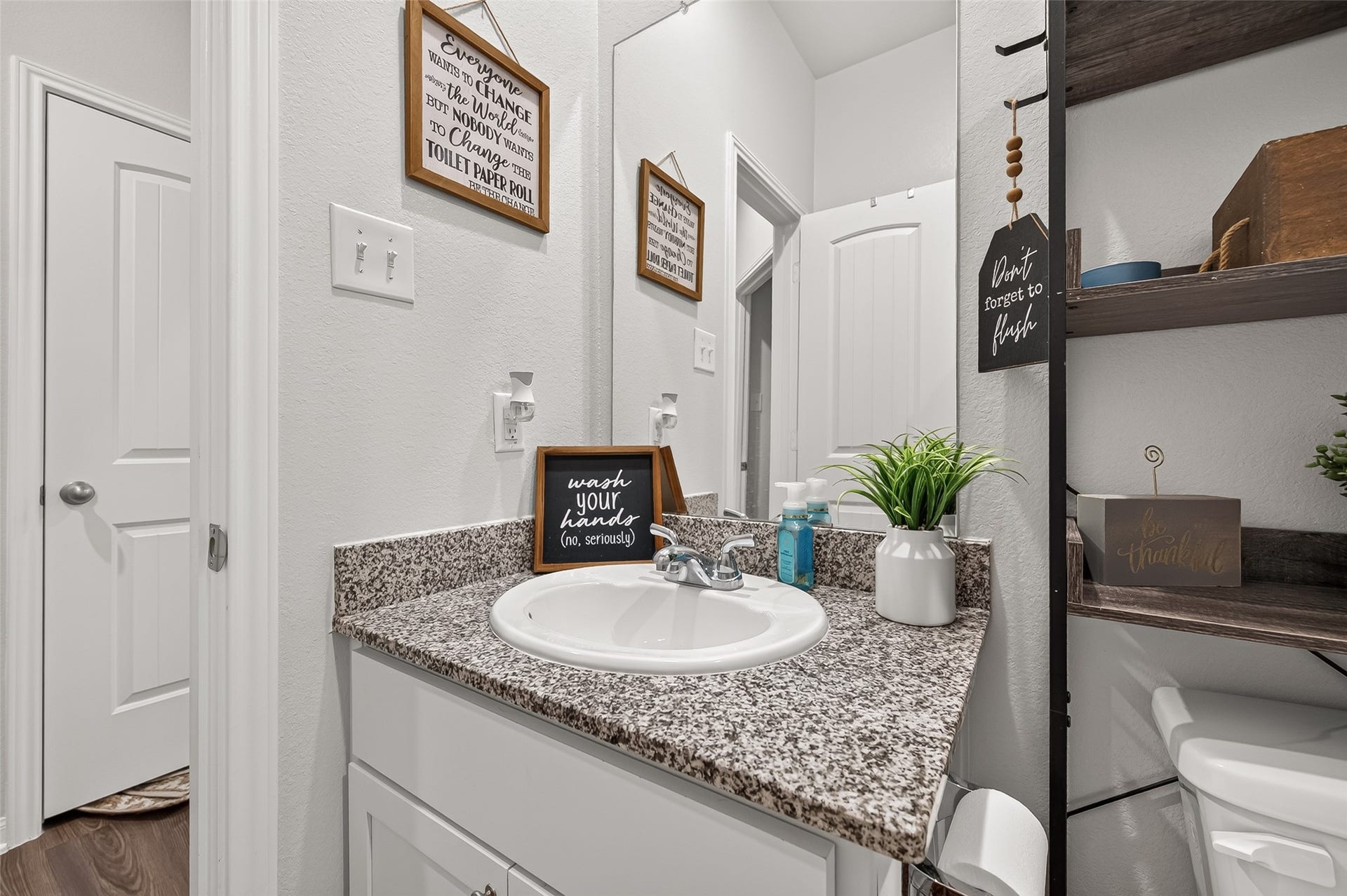 8422 Black Pearl Court, Texas City, TX 77591 Charming bathroom with modern granite countertop, stylish shelving, and a cozy decor touch, perfect for daily convenience.