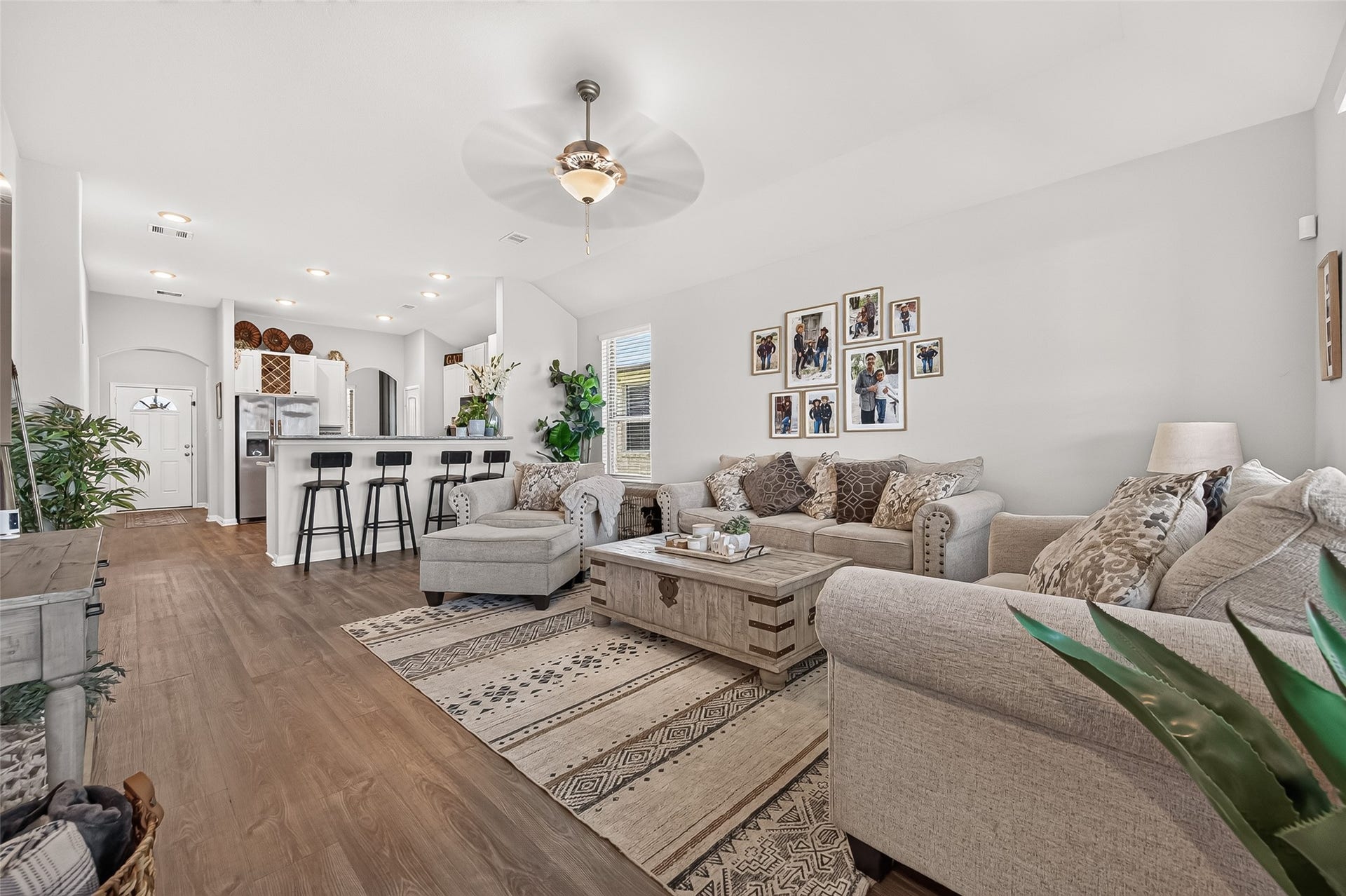 8422 Black Pearl Court, Texas City, TX 77591 Spacious open-concept living area with elegant hardwood floors, cozy seating, and a stylish kitchen featuring a breakfast bar with modern stools.