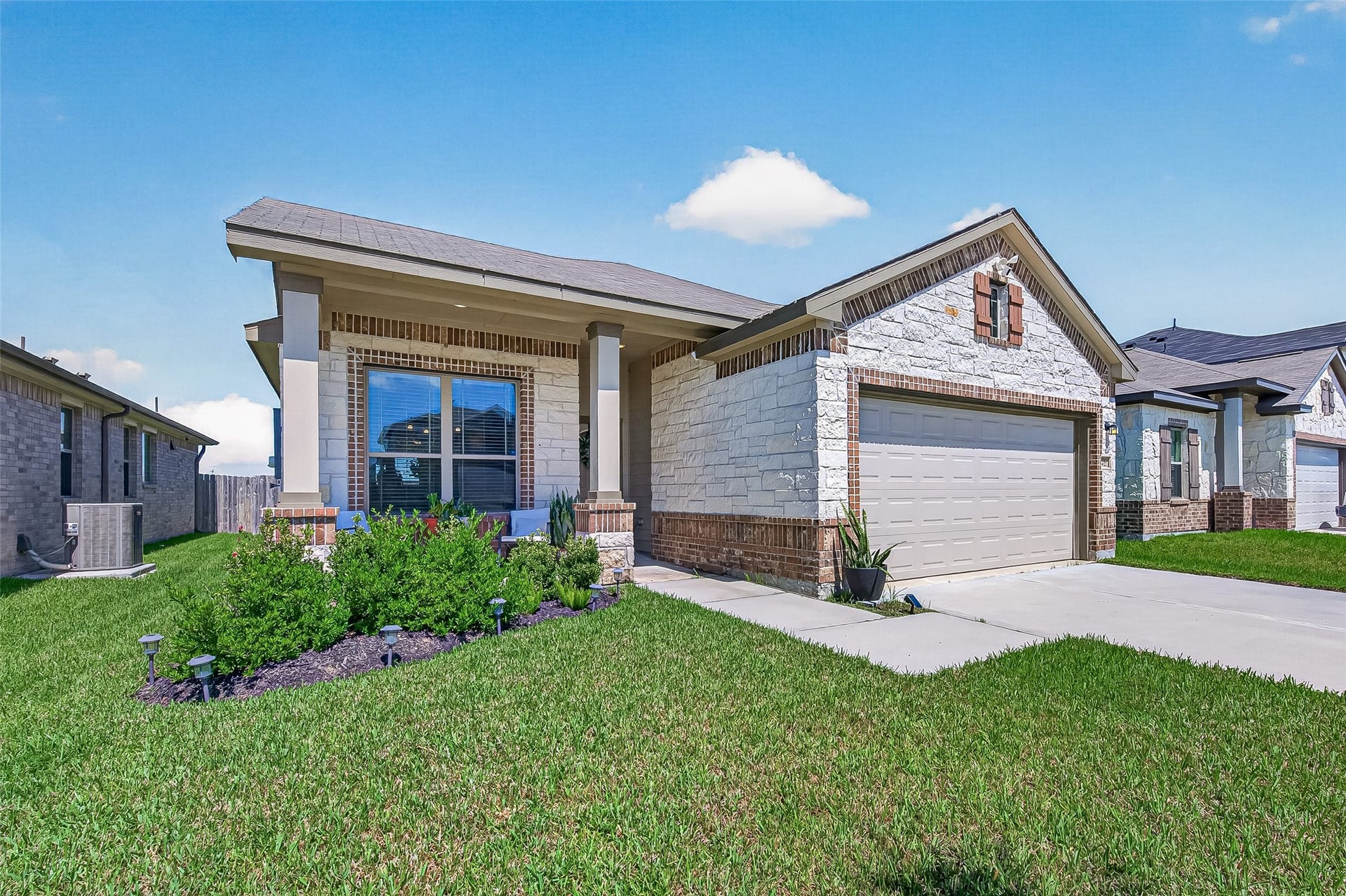 8422 Black Pearl Court, Texas City, TX 77591 Charming single-story home with a welcoming front porch, elegant brick and stone facade, and well-manicured landscaping.
