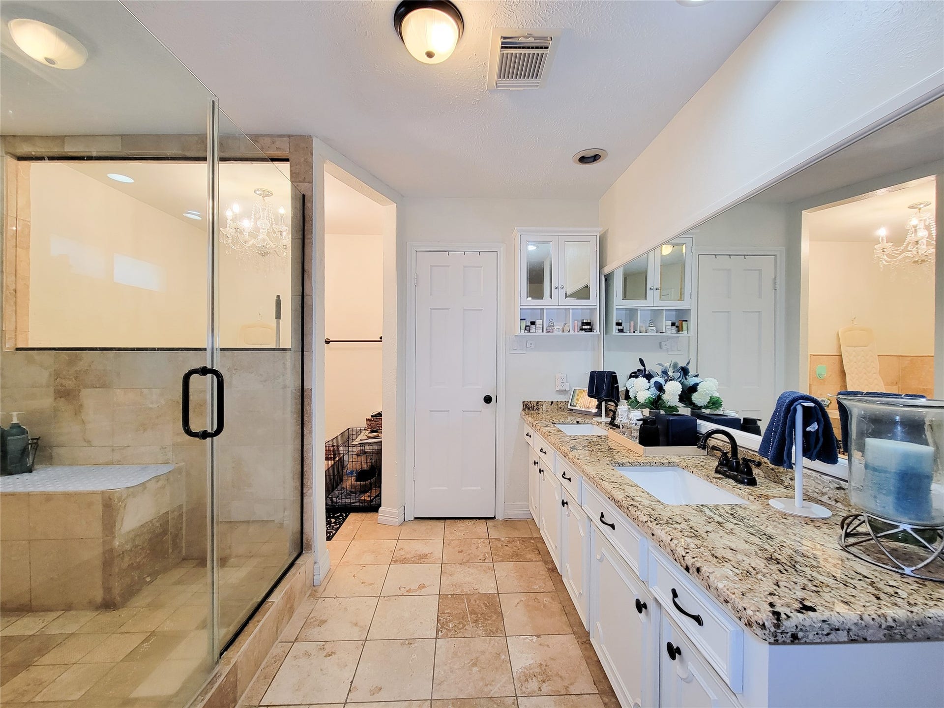 6235 Rolling Water Drive, Houston, TX 77069 This spacious bathroom features a large glass-enclosed shower with elegant tilework, a double-sink vanity with granite countertops, ample cabinet storage, and a bright, inviting atmosphere.