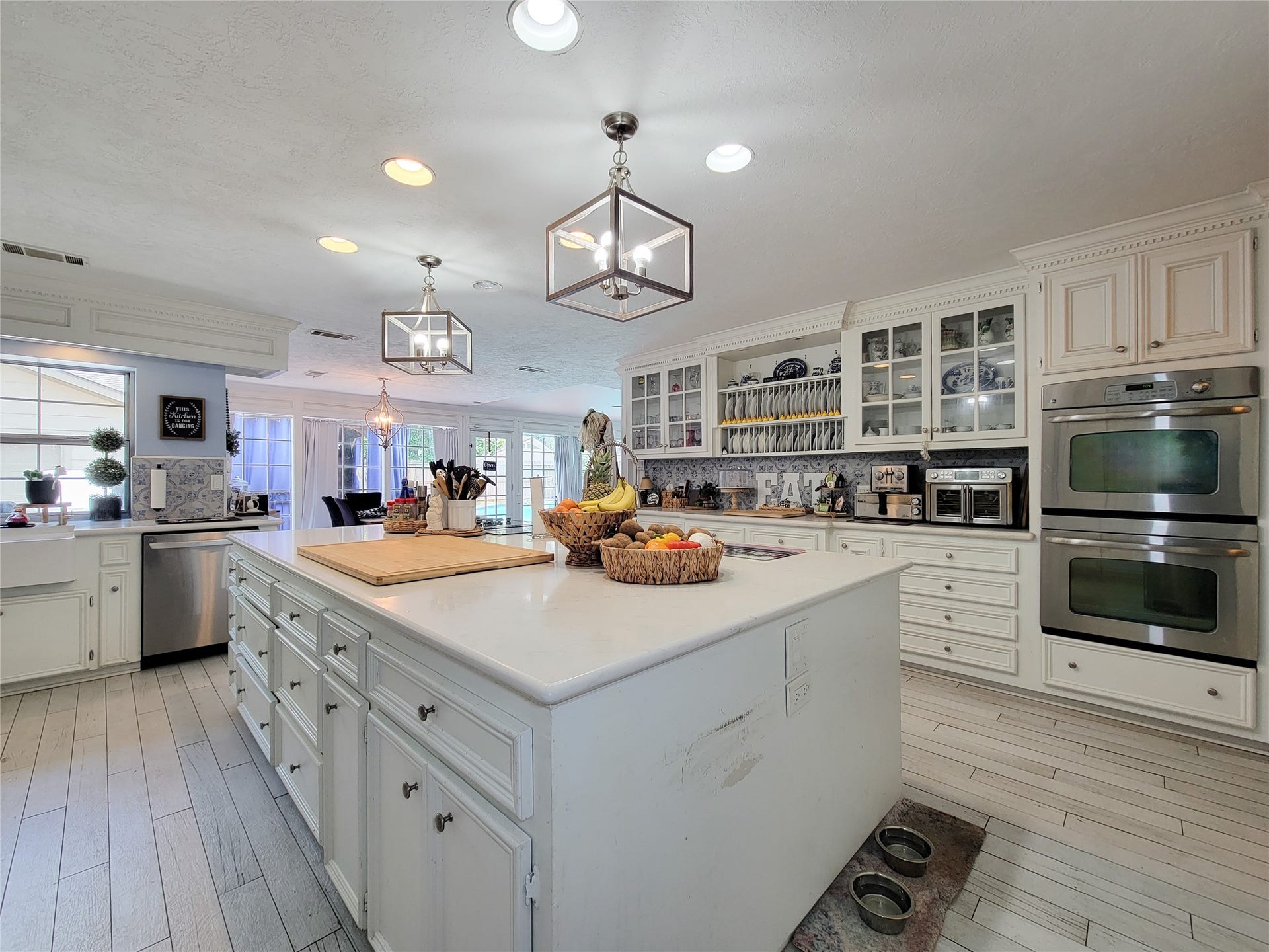 6235 Rolling Water Drive, Houston, TX 77069 This spacious kitchen features elegant white cabinetry, modern stainless steel appliances, and a large island with ample counter space. It offers abundant natural light and a cozy, inviting atmosphere, perfect for both cooking and entertaining.