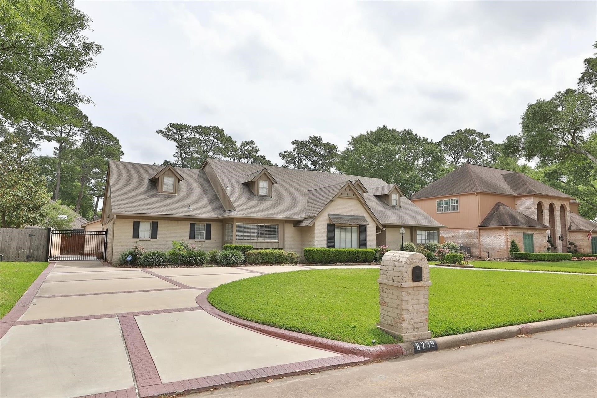 6235 Rolling Water Drive, Houston, TX 77069 This charming two-story home features a spacious driveway, manicured lawn, and a welcoming exterior with multiple dormer windows. It's set in a lush, green neighborhood, offering both privacy and curb appeal.