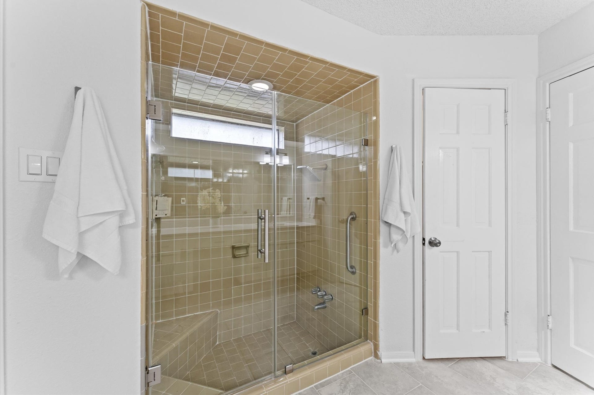 Fitted with two built-in benches, the tile-wrapped shower is a modern convenience.