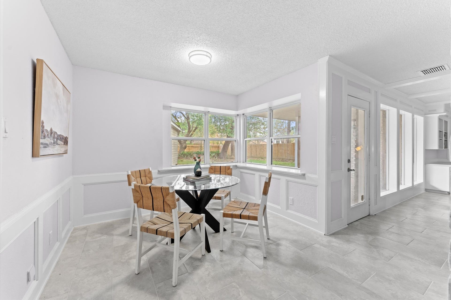 A charming breakfast room offers a view of a lovely backyard.