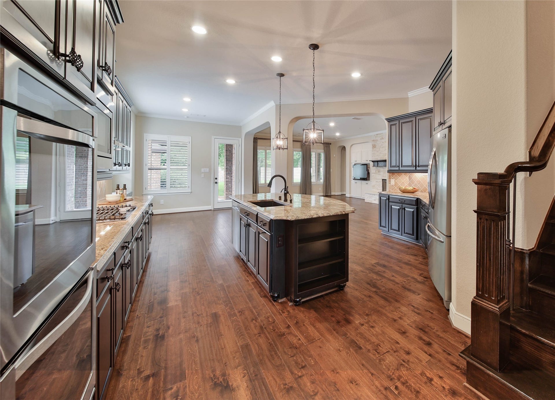 The open-concept kitchen offers plenty of space to prep, cook, and gather, while a convenient back staircase provides easy access to the upstairs living areas.