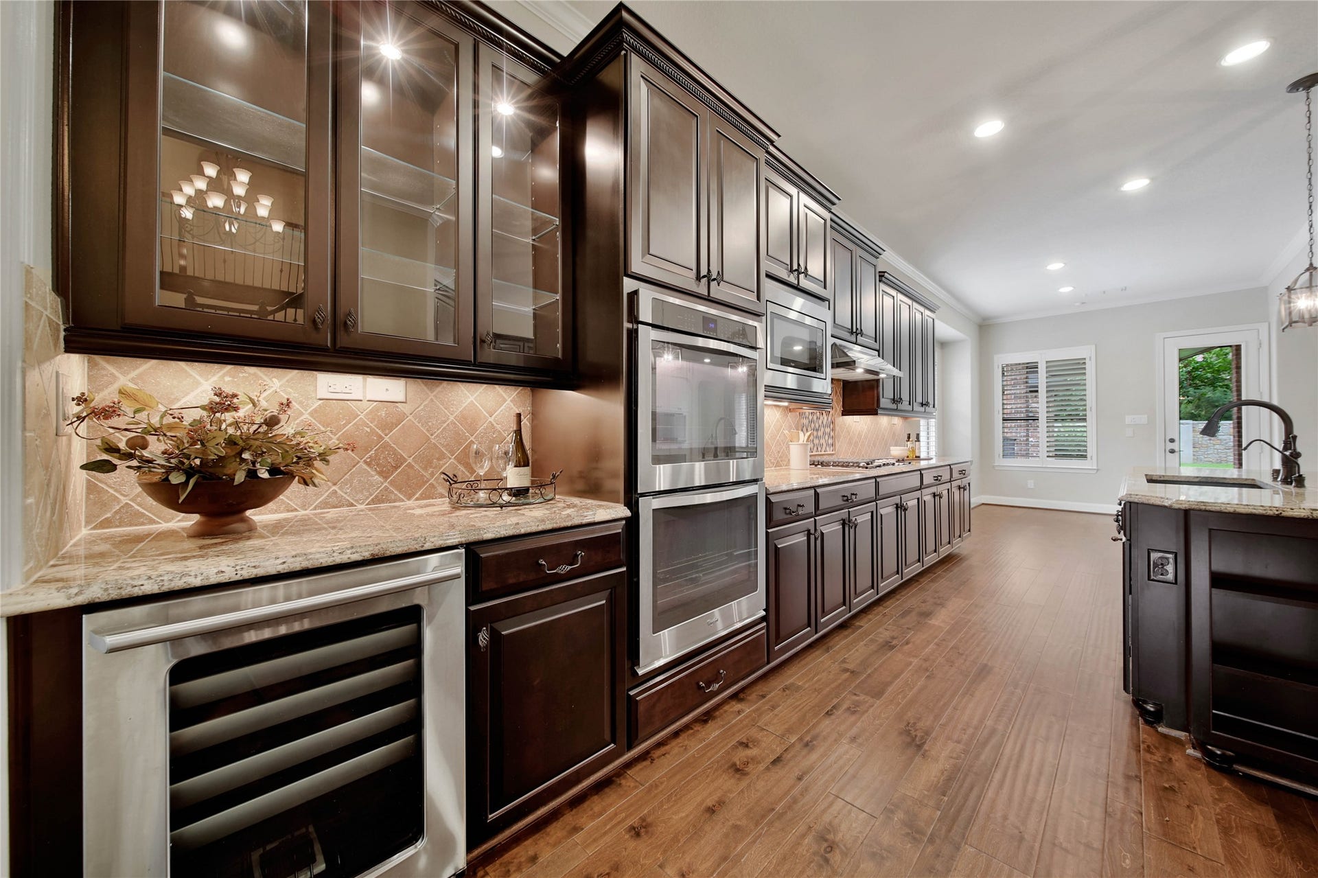 The butlers pantry adds both style and function with glass-front upper cabinets perfect for displaying stemware, along with a built-in beverage cooler for effortless entertaining.