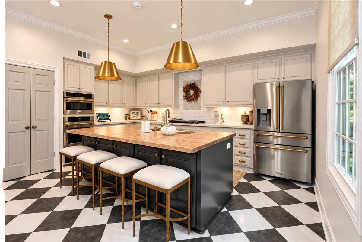 14026 Champions Hamlet Court, Houston, TX 77069 This refined kitchen pairs a wood-block island with seating for four and storage below, beautiful pendant lights overhead, and new Z Line stainless and champagne-gold appliances, all against an updated black-and-white tile floor.
