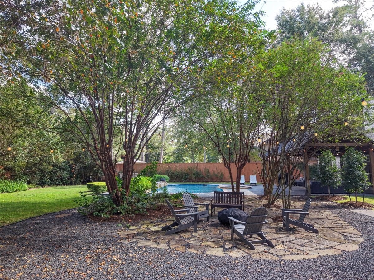 14026 Champions Hamlet Court, Houston, TX 77069 This flagstone fire pit seating area is tucked among the trees, a peaceful spot for cool nights with family and friends, with a mosquito system (2024) keeping the evenings comfortable.