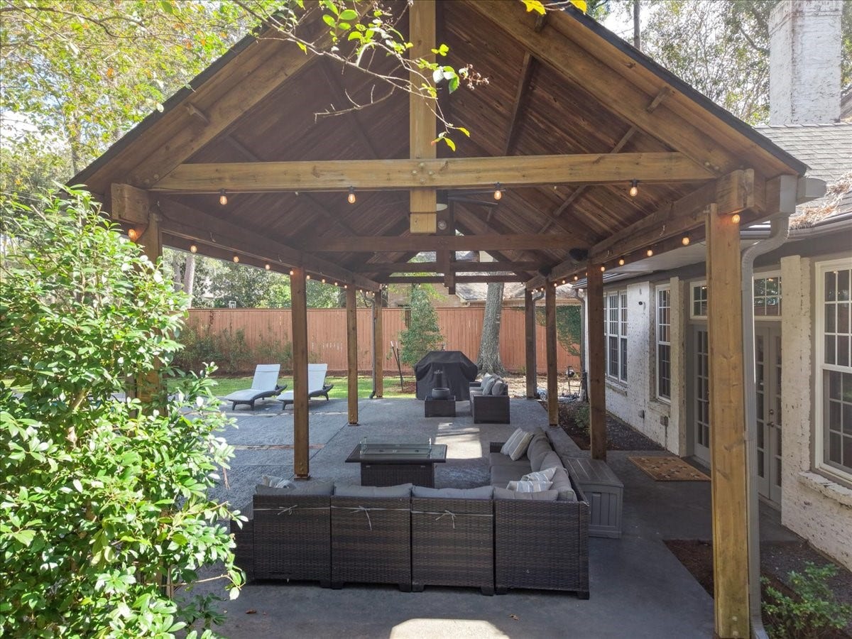 14026 Champions Hamlet Court, Houston, TX 77069 Step through the French doors onto this oversized covered patio, where cedar beams and warm string lights set the scene for morning coffee, game days, and long, easy evenings.