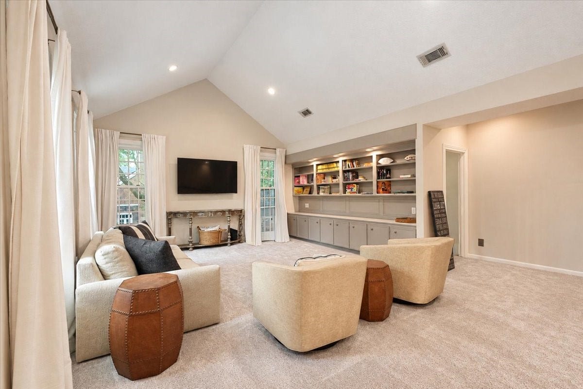 14026 Champions Hamlet Court, Houston, TX 77069 A wall of built-ins pairs open shelving with closed cabinetry below, so games, books, and keepsakes each have a place and the room stays clutter-free.