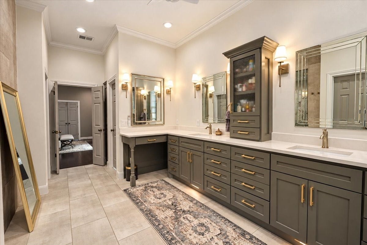 14026 Champions Hamlet Court, Houston, TX 77069 Start your day in style! This primary bath was fully refreshed with new tile flooring and redone cabinetry, finished with gold hardware and a double vanity that gives you generous counter space and storage on both sides. Automatic shades with remote for light and privacy at the touch of a button.