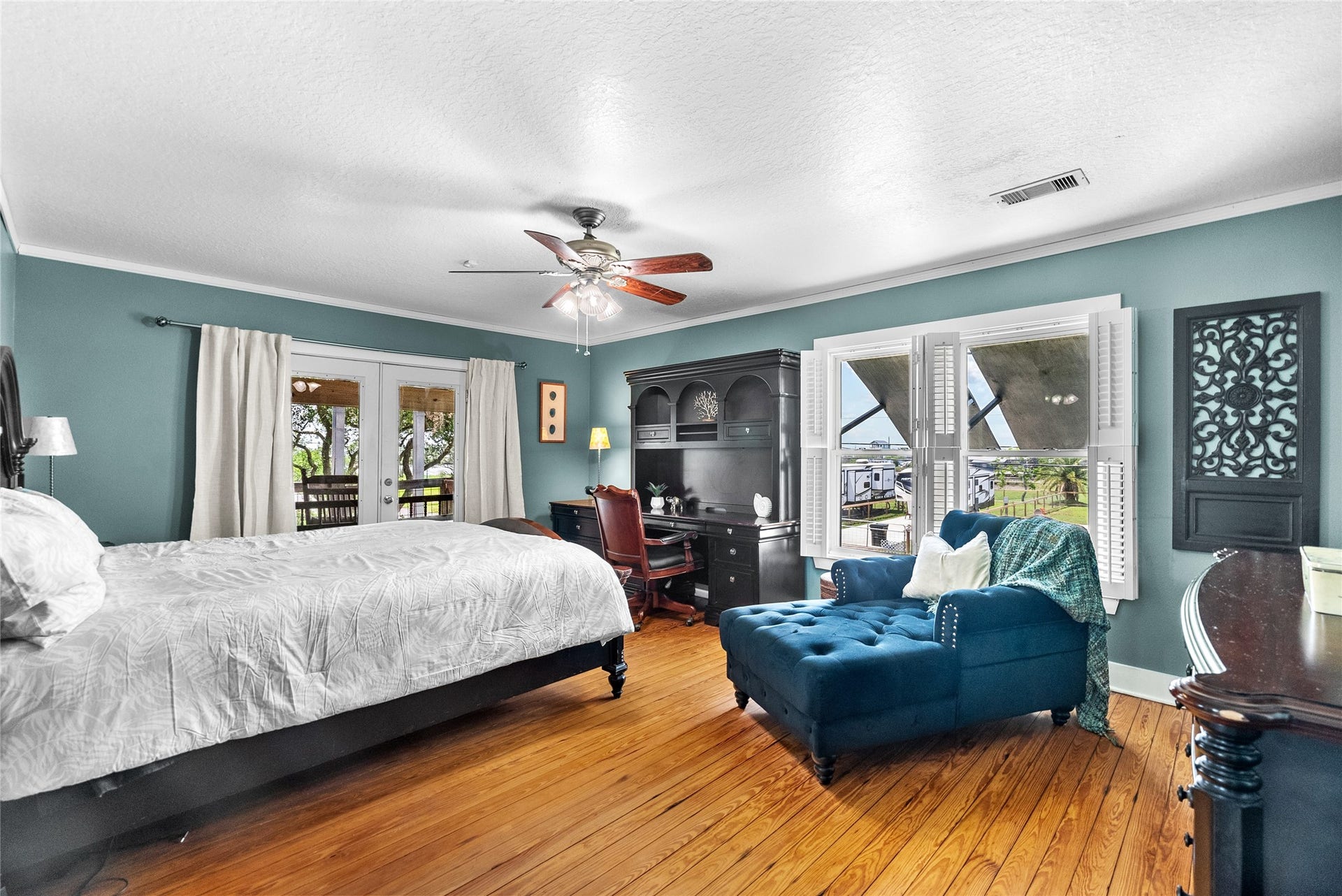 939 17th Street, Dickinson, TX 77539 Generously sized primary suite highlighting the hardwood floors, abundant natural light, and direct outdoor access