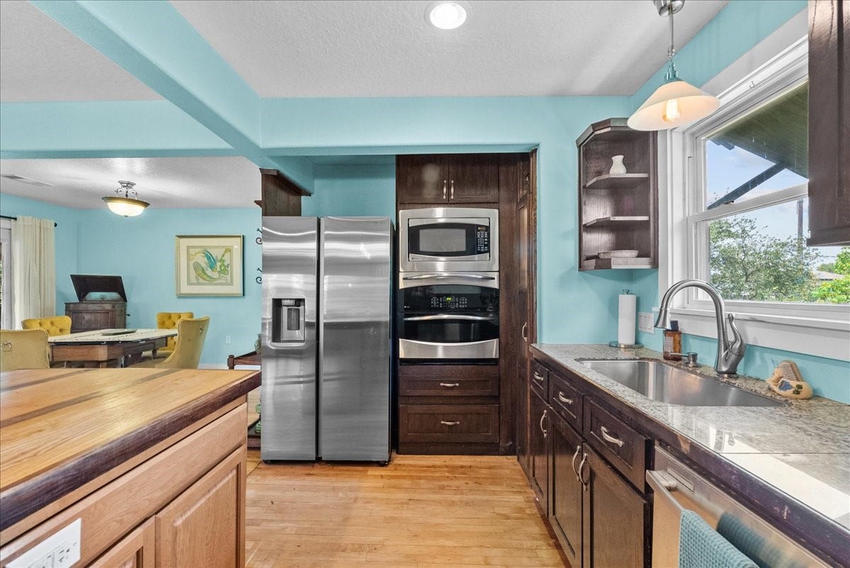 939 17th Street, Dickinson, TX 77539 Kitchen features granite countertops, stainless steel appliances, generous cabinetry and a window above the sink bringing in natural light