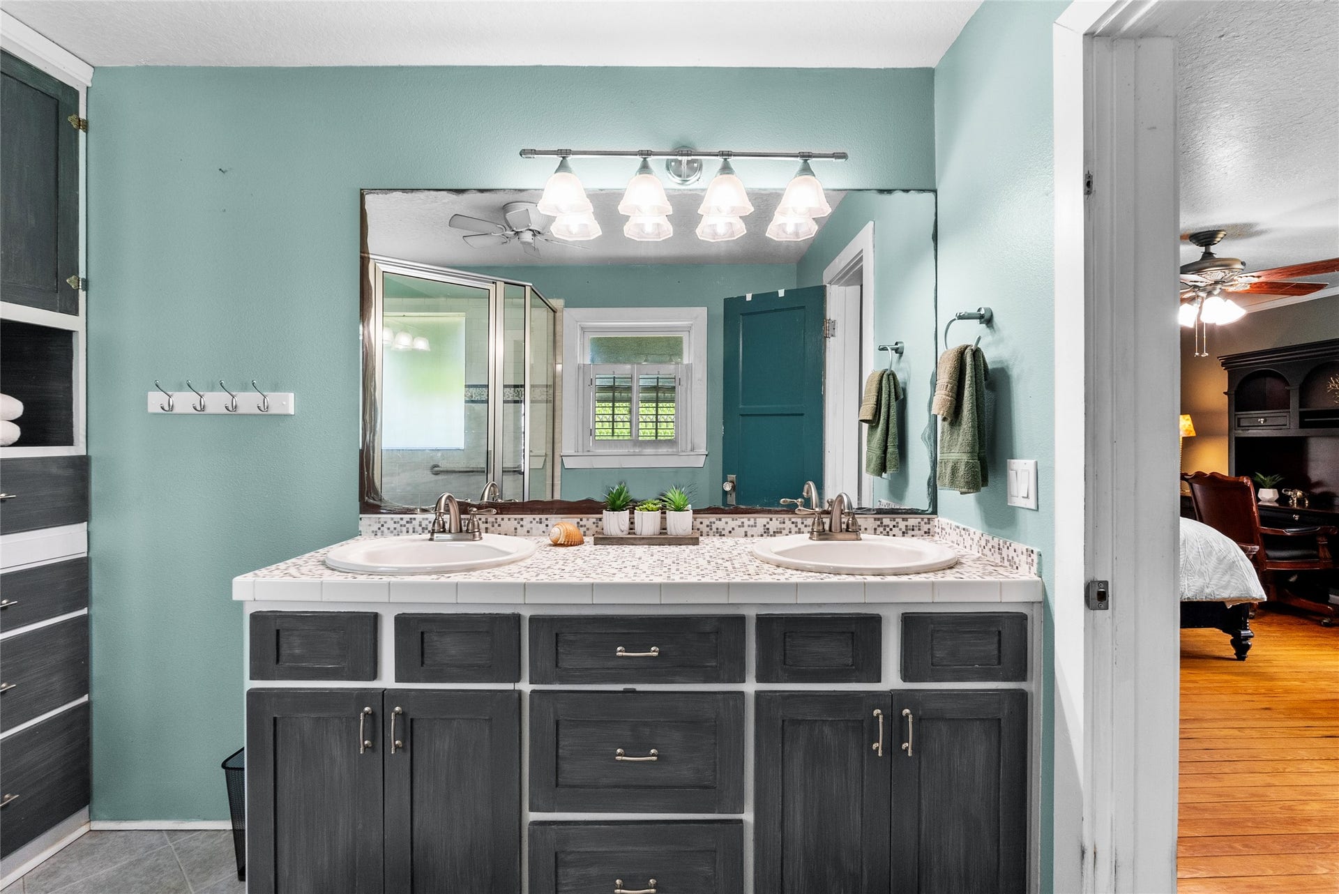 939 17th Street, Dickinson, TX 77539 Primary bathroom offers a dual-sink vanity, extensive counter space, storage cabinetry and an oversized mirror