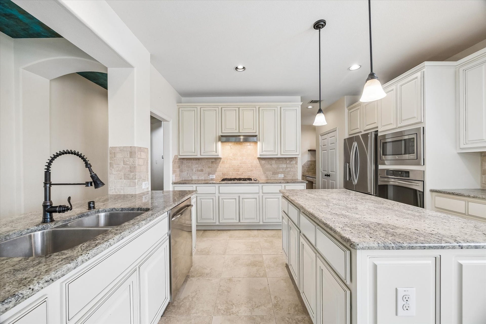 Well-appointed kitchen featuring a large prep island, gas cooktop, built-in oven and microwave, and stainless steel appliances.