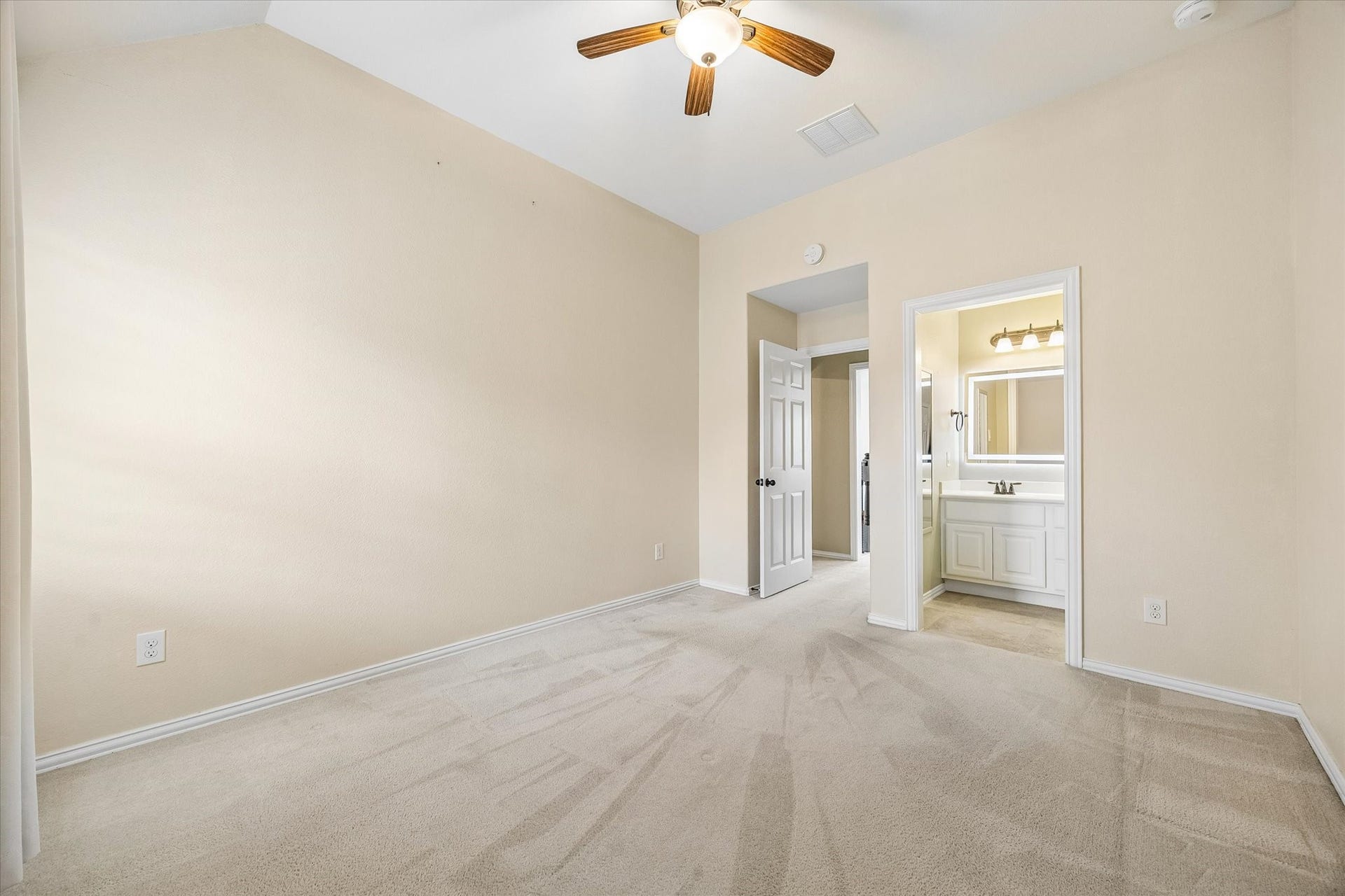Upstairs guest bedroom features a high ceiling, ceiling fan, and direct access to the shared Jack-n-Jill bath.
