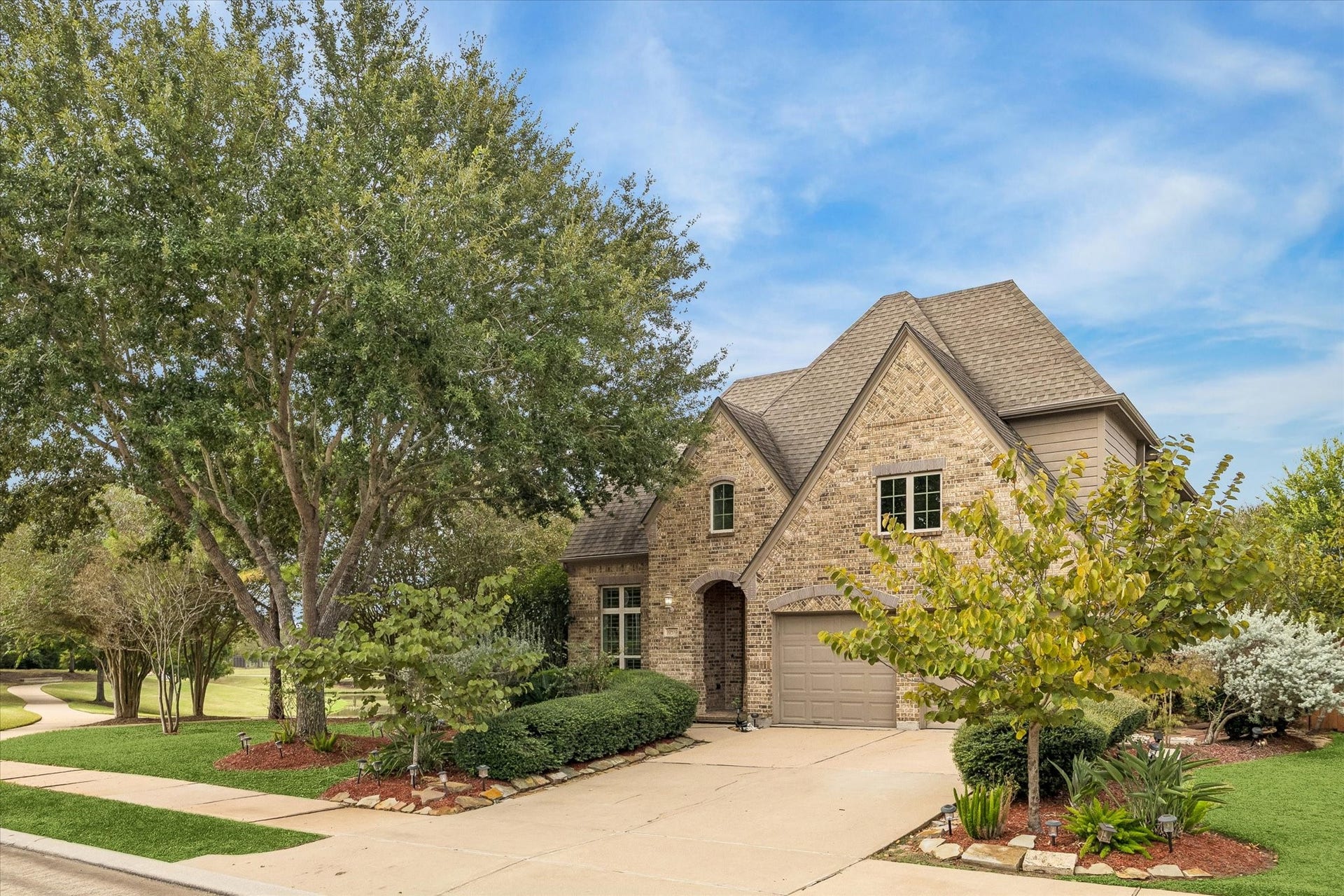 A charming arched entry and distinctive rooflines create a lovely curb appeal and a warm welcome.