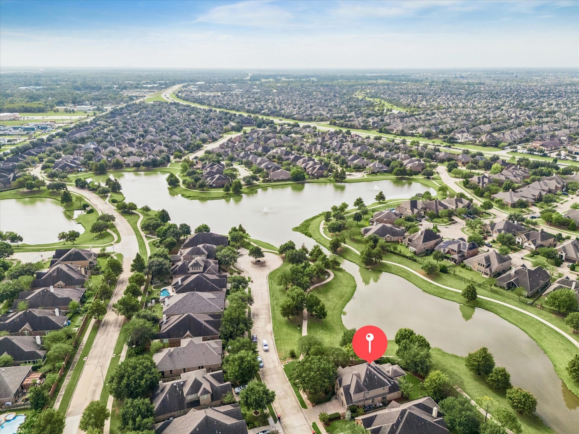 Water, winding trails, and stretches of green space define the landscape surrounding this home, marked here to show its enviable position beside the lake.