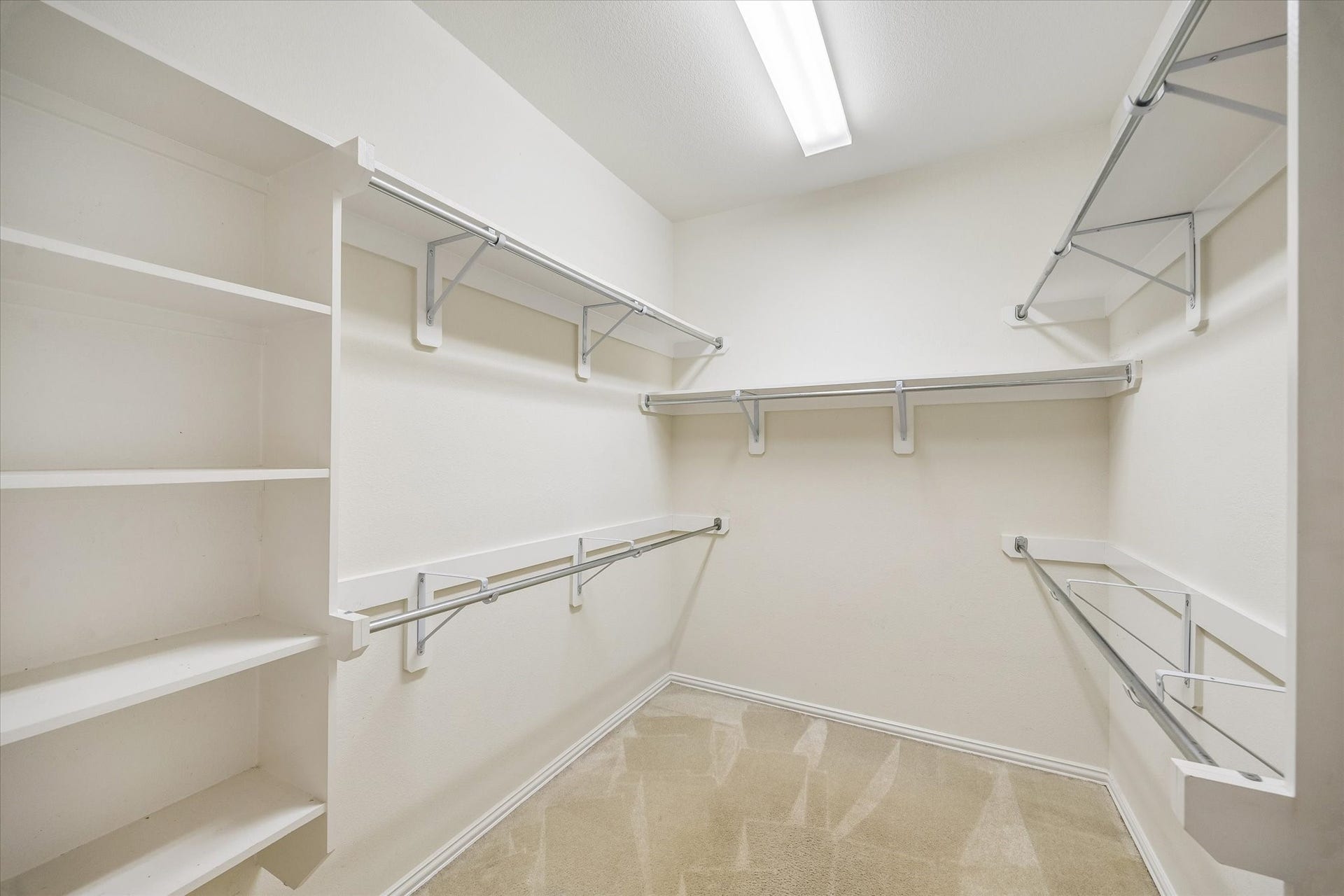 Spacious primary walk-in closet offers multiple space and built-in shelving for organized storage of clothing, shoes and accessories.